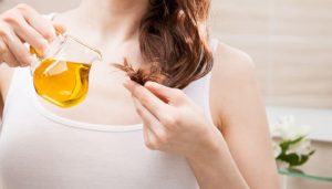 woman-applying-oil-mask-to-hair-tips-768x437
